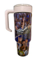 A handled travel tumbler with a printed soccer player design, shown lying on a white shelf against a white wall.